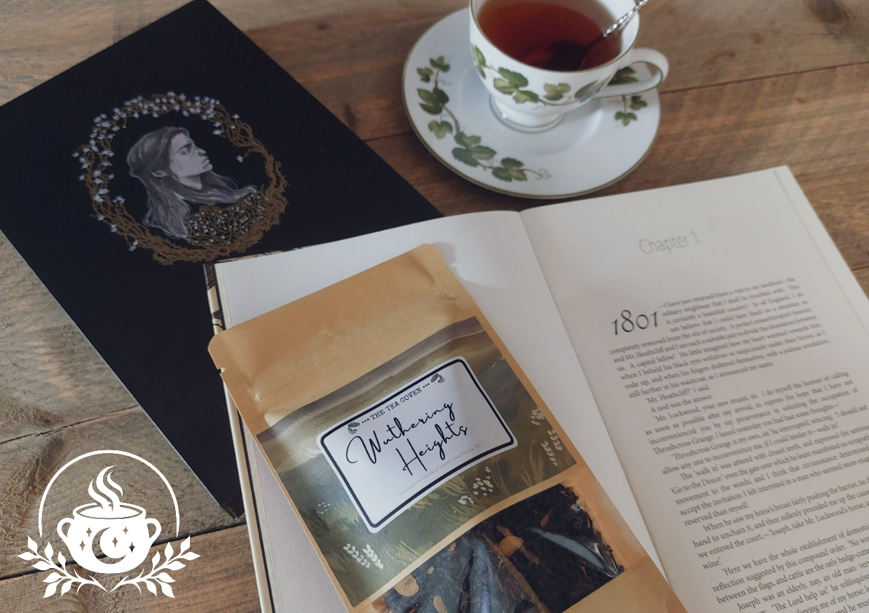 A bag of tea with Wuthering Heights on the label on a landscape watercolour painting. It is placed on a table with a cute cup of dark looking tea, on top of the classic book by Emily Bronte.